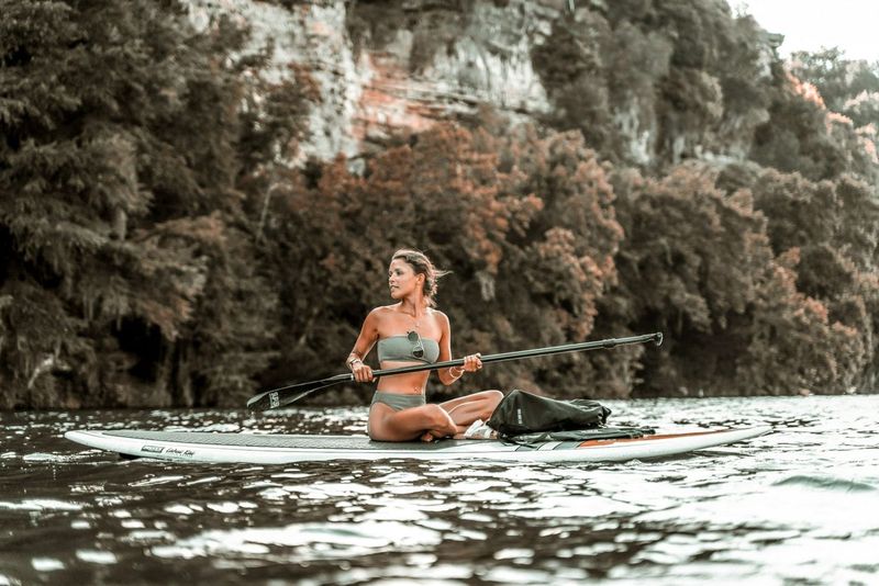 Woman Paddleboarding on a lake with a mountainous backdrop