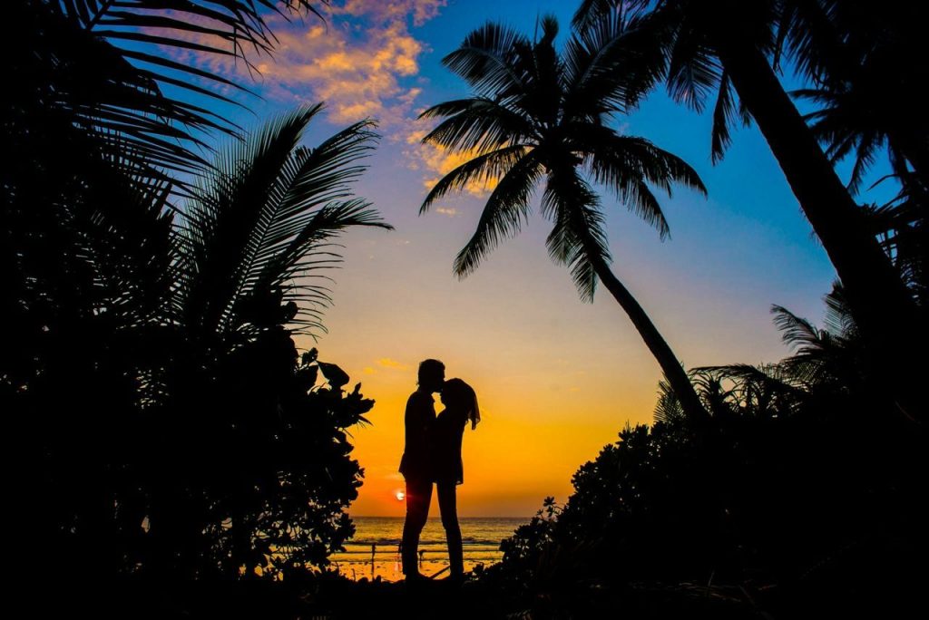 Silhouetted couple on a beach in the Maldives at Sunset