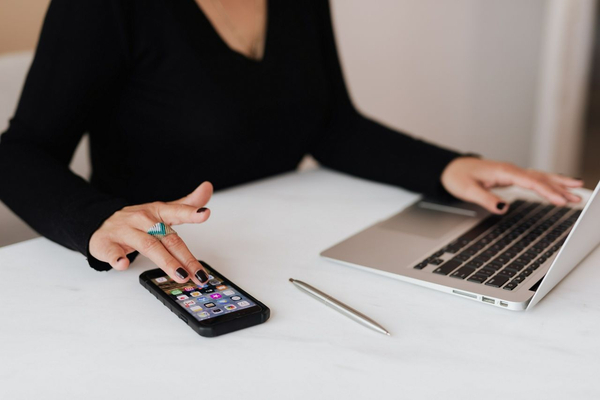 woman using phone and laptop at the same time