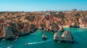 Stunning aerial shot of the rocky coastline in Lagos, Portugal's Algarve region, with clear blue sea.